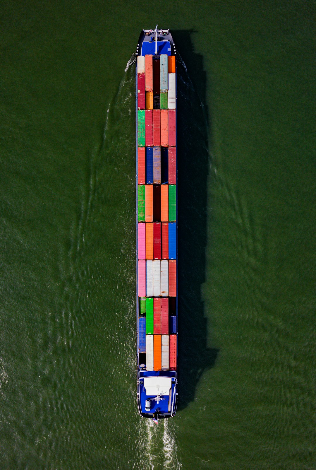 The Art of Drawing Readers In: Your attractive post title goes here Captured from above, a cargo barge adorned with a mosaic of colorful containers makes its way down a river, vivid against the waters surface, exemplifying the essential role of inland waterways in global trade and logistics.